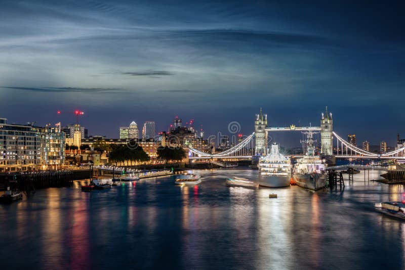 View to the skyline of London, UK, during night time over the Thames river to the Tower Bridge and Canary Wharf district