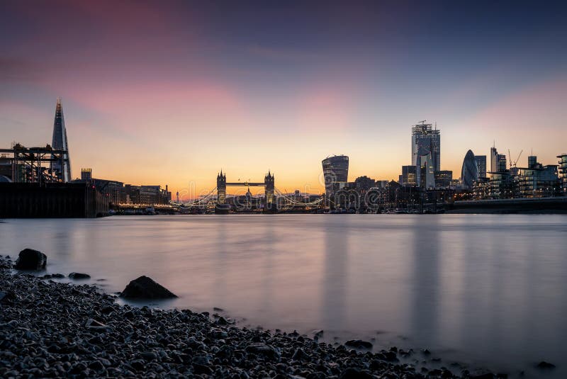 The skyline of London, UK, during sunset time seen from the Thames river to the Tower Bridge and City