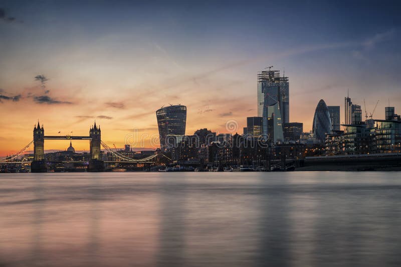 The skyline of London, UK, during sunset time seen from the Thames river to the Tower Bridge and City