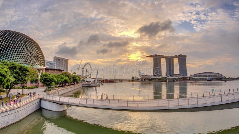 Skyline in Marina Bay with Esplanade Theaters on the Bay and Esplanade footbridge early morning timelapse in Singapore.