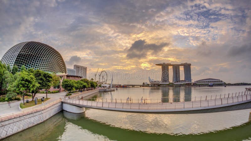 Skyline in Marina Bay with Esplanade Theaters on the Bay and Esplanade footbridge early morning timelapse in Singapore.