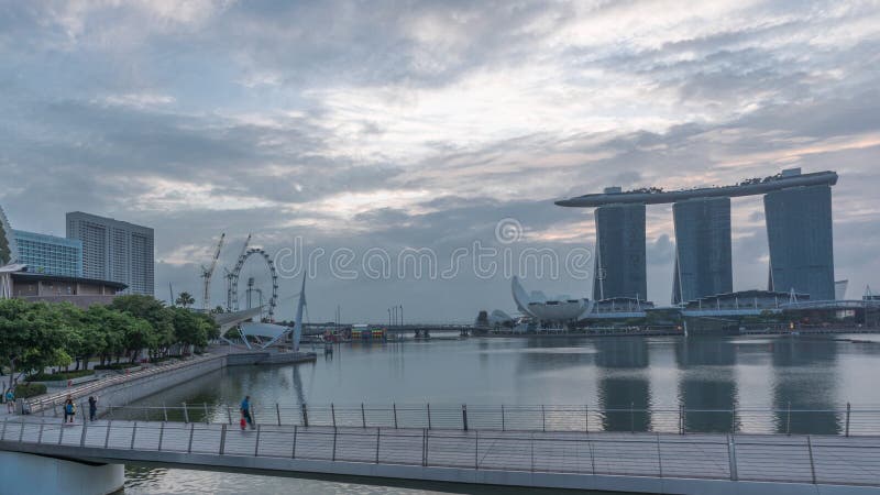 Skyline in Marina Bay with Esplanade Theaters on the Bay and Esplanade footbridge night to day timelapse in Singapore.