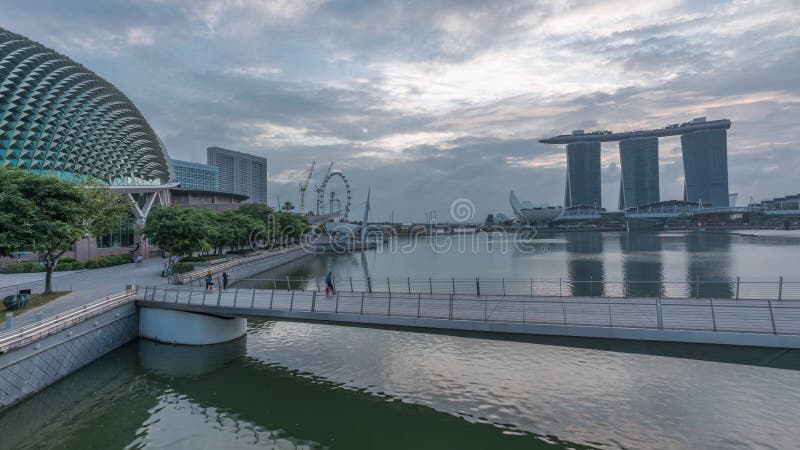 Skyline in Marina Bay with Esplanade Theaters on the Bay and Esplanade footbridge night to day timelapse in Singapore.