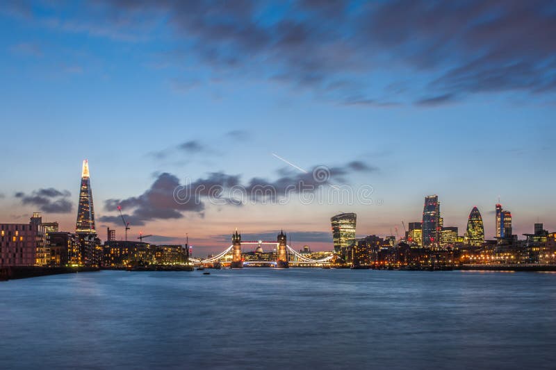 A skyline nova de Londres na noite com o estilhaço, a ponte da torre e os arranha-céus da cidade imagens de stock A skyline nova de Londres na noite com o estilhaço, a ponte da torre e os arranha-céus da cidade imagens de stock