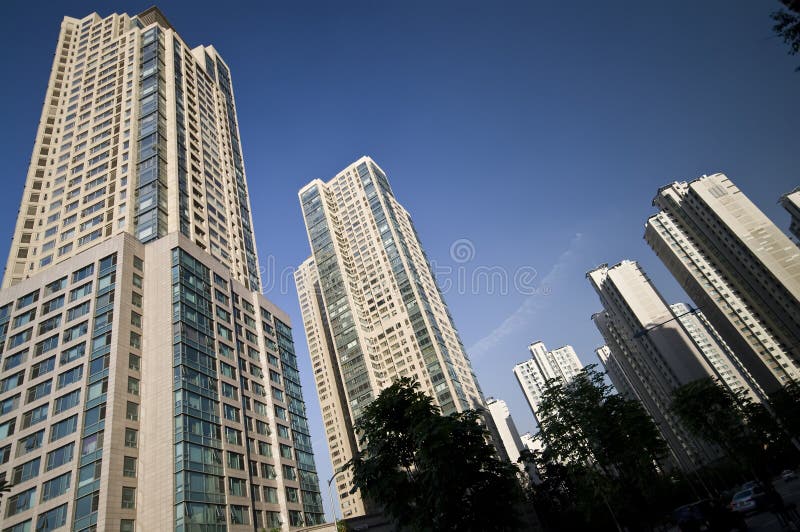 Low angle view of modern office skyscraper buildings with blue sky background.