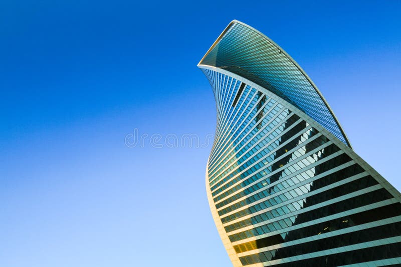 Skyscraper exterior. Modern office building, glass facade in blue sky. Urban view, looking up city, skyline.