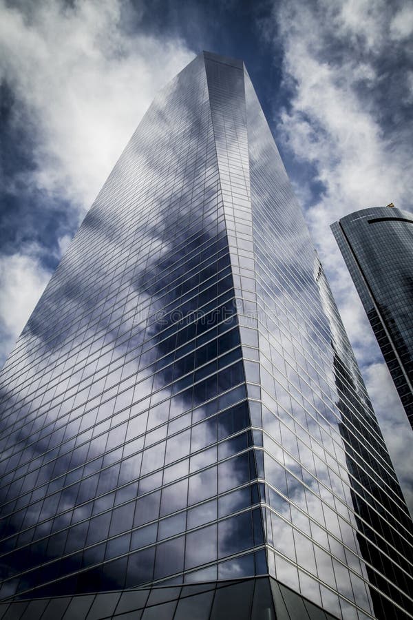 Skyscraper with Glass Facade and Clouds Reflected in Windows Stock