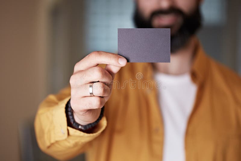 Skäggig ung man som ger hand det tomma svarta affärskortet på suddig bakgrund Tom annonsering f?r modellkopieringsdeg arkivbilder Skäggig ung man som ger hand det tomma svarta affärskortet på suddig bakgrund Tom annonsering f?r modellkopieringsdeg arkivbilder