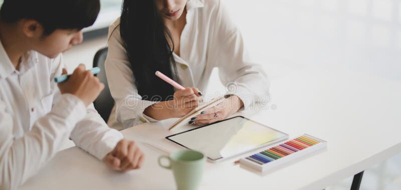 Skärmdump av unga professionella grafikdesigner som arbetar med sitt projekt tillsammans med en tablett på modernt kontor arkivbilder