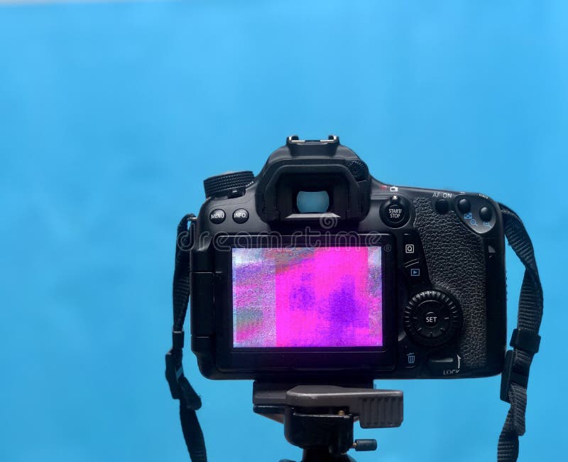 Skärmskärm för DSLR LCD med PIXELtextur av kameramatrisen på en tripod på blå bakgrund royaltyfri bild Skärmskärm för DSLR LCD med PIXELtextur av kameramatrisen på en tripod på blå bakgrund royaltyfri bild