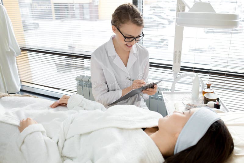 SkönhetCosmetologist med klienten royaltyfria bilder SkönhetCosmetologist med klienten royaltyfria bilder