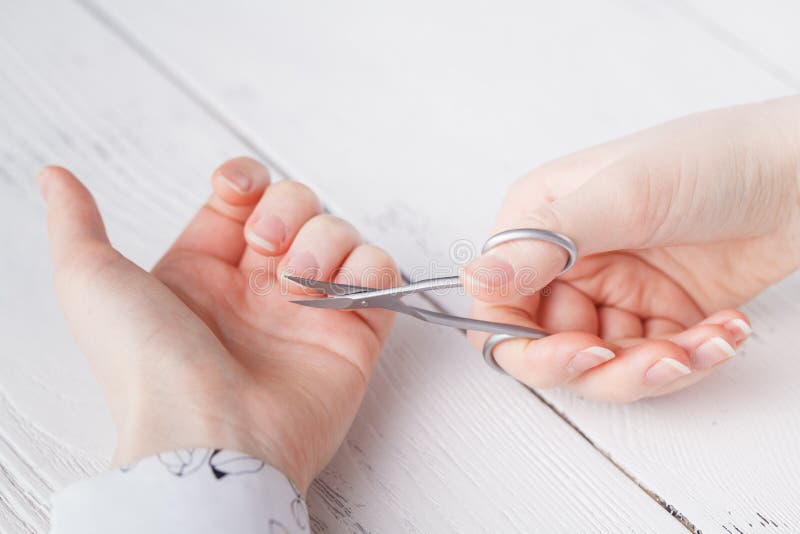 Skönhetsalong, applicera för manikyr som klipper nagelbandet med scisso arkivfoton Skönhetsalong, applicera för manikyr som klipper nagelbandet med scisso arkivfoton