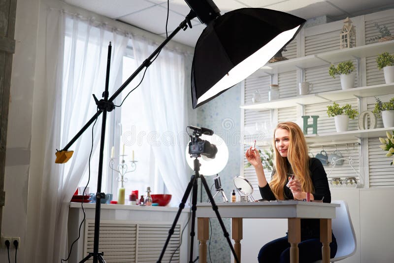 Skönhetsbloggare, kvinna som filmar daglig makeup-rutin på kamera. Inflytelserika blonda flickor direktuppspelning av kosmetika royaltyfri bild