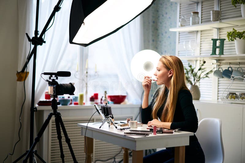 Skönhetsbloggare, kvinna som filmar daglig makeup-rutin på kamera. Inflytelserika blonda flickor direktuppspelning av kosmetika arkivfoton