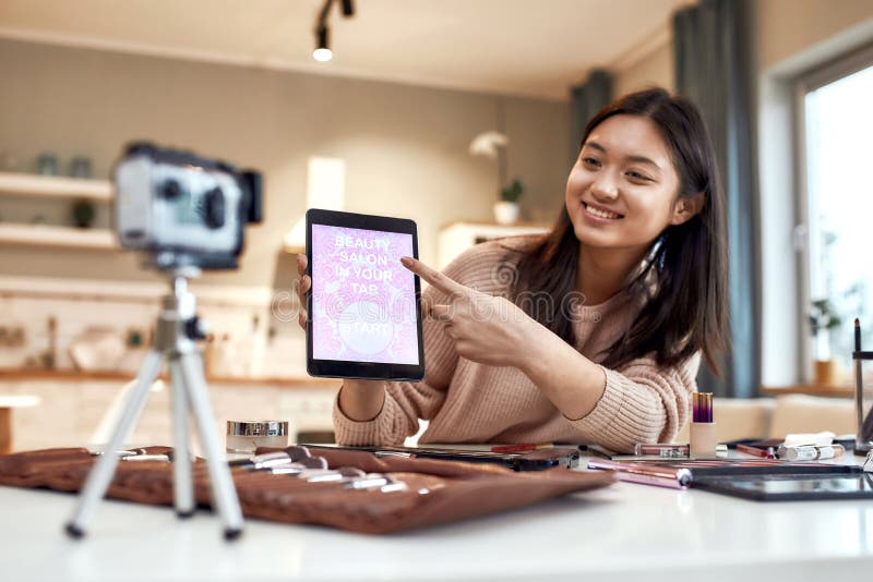 Skönhetsbloggare, kvinna som filmar reklamapp på kamerahållplatta pc. makeup influencer asia Girl arkivbilder