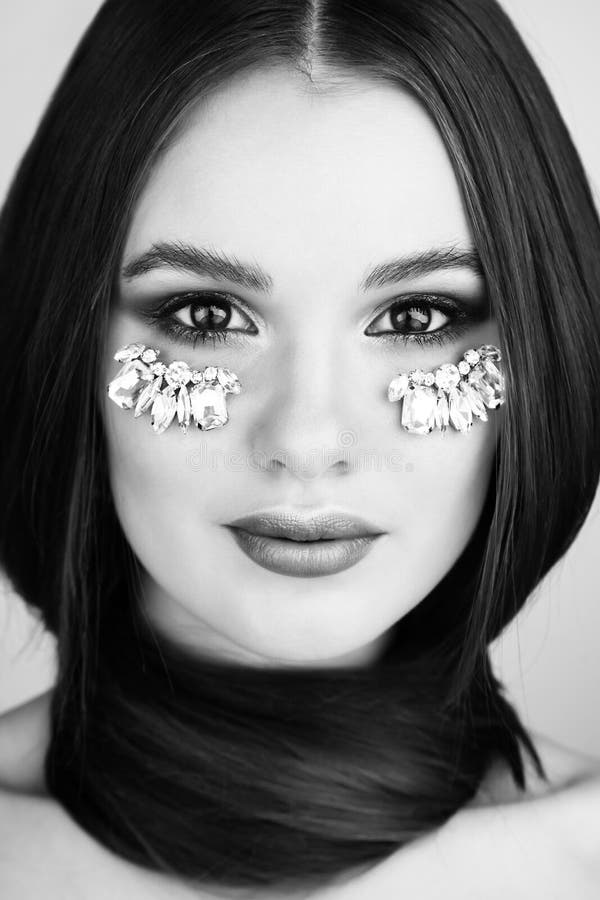 Skönhetstående av den attraktiva kvinnan med ljus makeup och juveln royaltyfri fotografi Skönhetstående av den attraktiva kvinnan med ljus makeup och juveln royaltyfri fotografi
