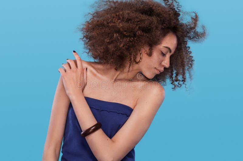 Skönhetstående av flickan med den afro frisyren Flicka som poserar på blå bakgrund härlig för studiokvinna för par dans skjutit b royaltyfri foto Skönhetstående av flickan med den afro frisyren Flicka som poserar på blå bakgrund härlig för studiokvinna för par dans skjutit b royaltyfri foto