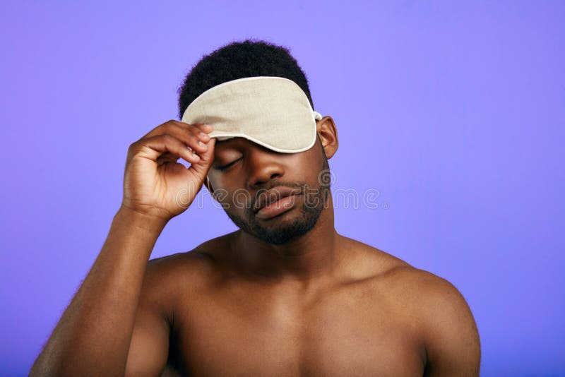 Slaperige vermoeide mens die of op het slaapmasker opstijgen zetten stock afbeeldingen Slaperige vermoeide mens die of op het slaapmasker opstijgen zetten stock afbeeldingen