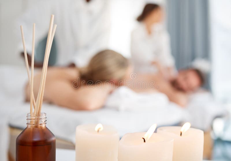 Relax like your life depends on it. some candles and a couple getting a massage in the background in a spa. Relax like your life depends on it. some candles and a couple getting a massage in the background in a spa