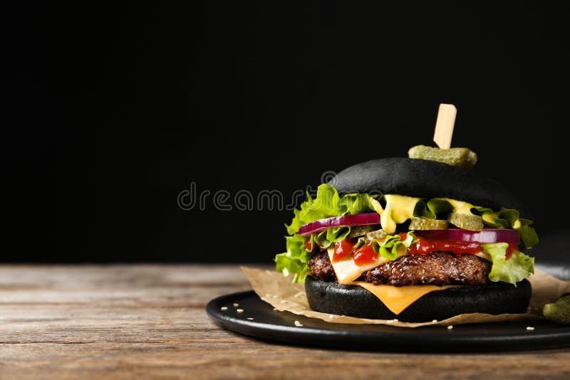Slate plate with black burger on table