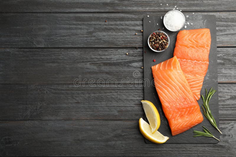 Slate plate with salmon fillet on black wooden table, flat lay royalty free stock images Slate plate with salmon fillet on black wooden table, flat lay royalty free stock images