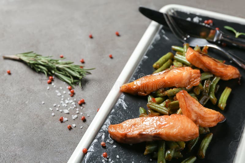 Slate Plate with Tasty Fried Fish and Green Beans on Grey Table Stock