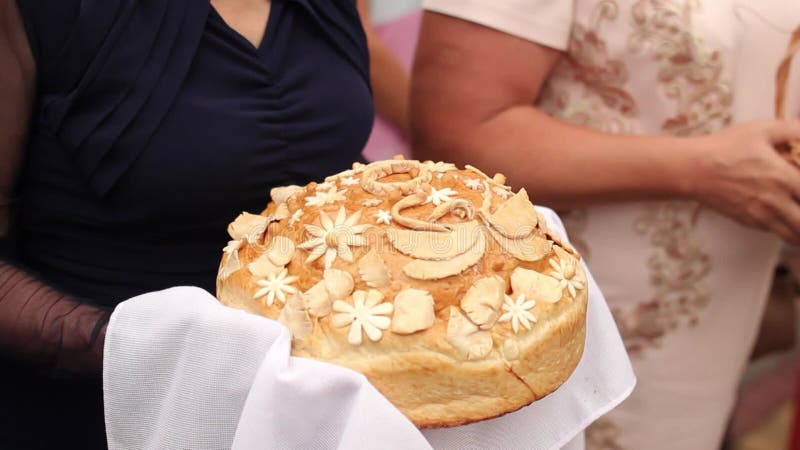 Slavic wedding tradition, parents offer bread salt to bride groom. Festive loaf presented at ceremony, symbol for