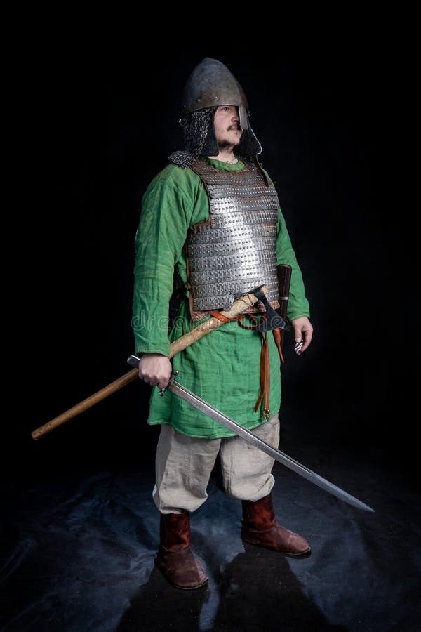 Slawischer Wikinger-Alterskrieger in der Rüstung und Sturzhelm mit Klinge und Axt stockfoto Slawischer Wikinger-Alterskrieger in der Rüstung und Sturzhelm mit Klinge und Axt stockfoto