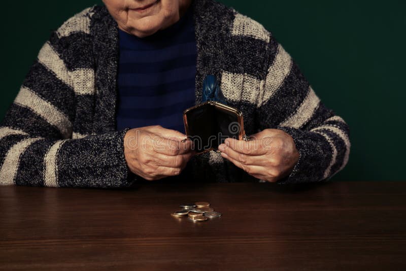Slechte hogere vrouw met lege portefeuille en muntstukken bij lijst stock afbeeldingen Slechte hogere vrouw met lege portefeuille en muntstukken bij lijst stock afbeeldingen