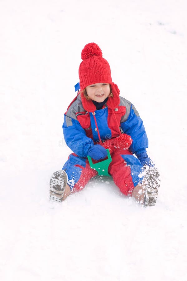 Little child sledding on a cold winter day