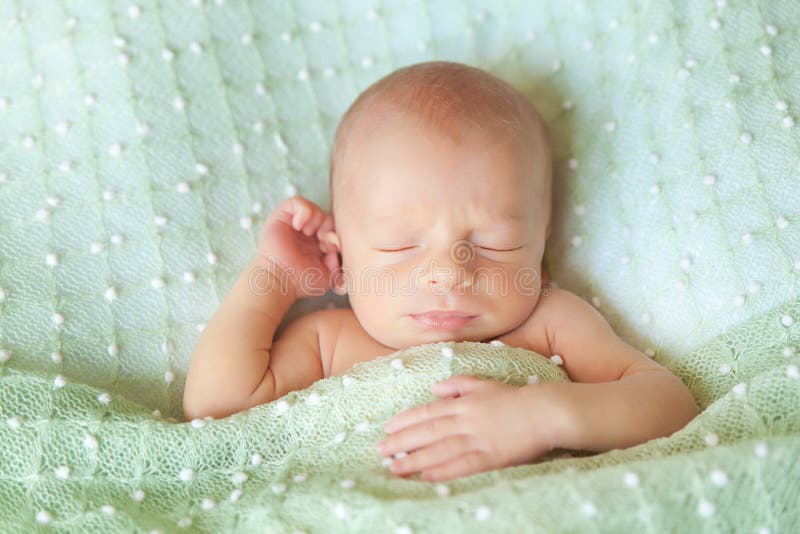 Sleeping Cute Newborn Baby on a Yellow Chunky Knit Blanket Stock Photo