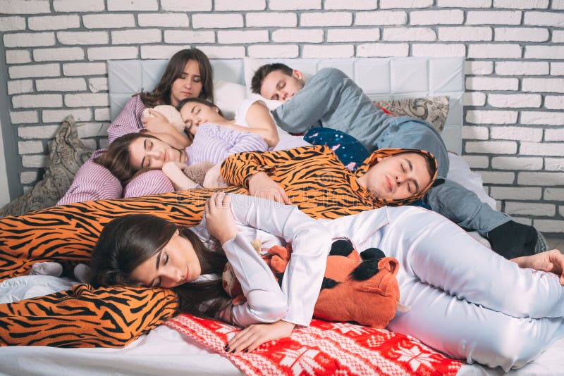 Sleeping Group Of Young People On The Bed. Stock Photo - Image of lying,  culture: 155365406