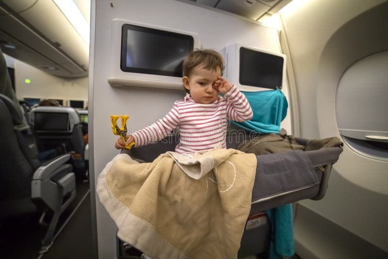 Sleepy Little Cute Toddler Sitting in the Bassinet an Airplane with Toy Rubs His Eyes. Close-up, Soft Stock Photo - Image of economy, happy: 179218828