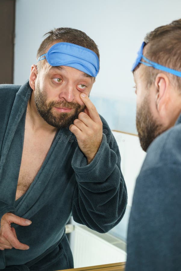 Sleepy man looking at mirror