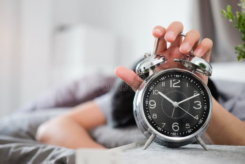 Sleepy Man Lying On Bed And Reaching To Turn Off Alarm Clock Switch In