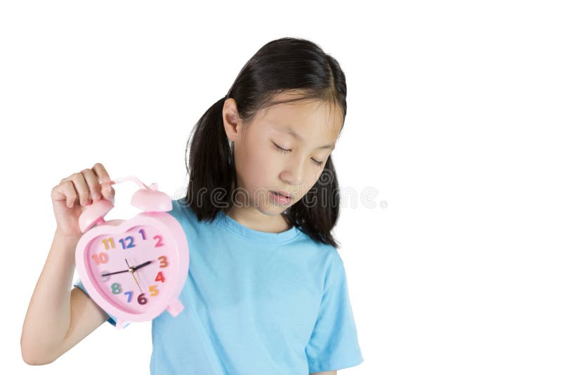 Sleepy portrait of asian girl holding clock isolated on white ba stock photo Sleepy portrait of asian girl holding clock isolated on white ba stock photo