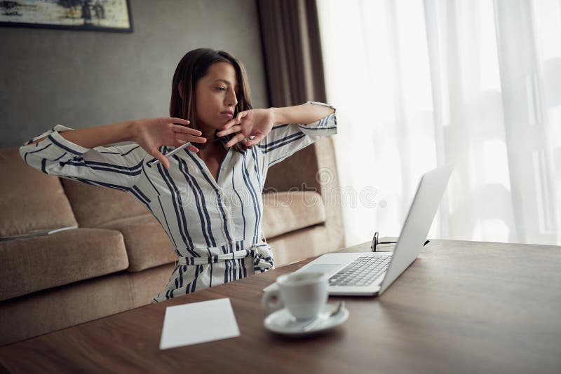 Sleepy woman working at home with a laptop as a freelancer stock image Sleepy woman working at home with a laptop as a freelancer stock image