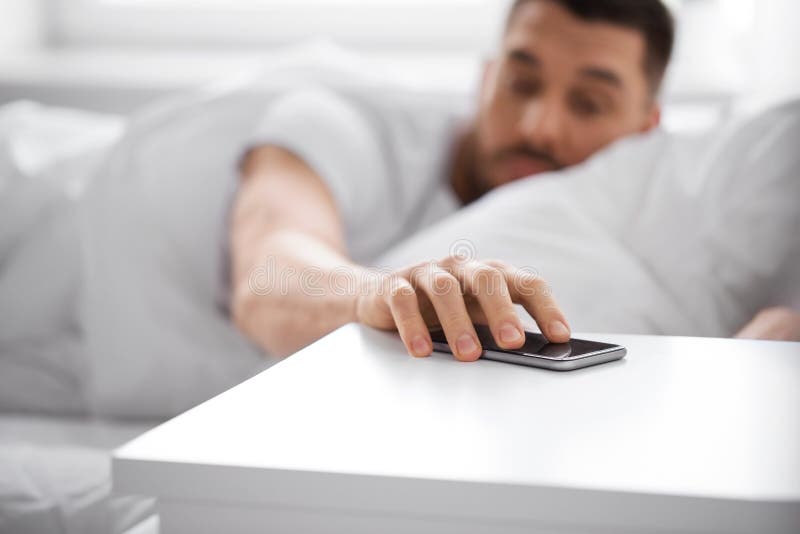 Sleepy Young Man Reaching For Smartphone In Bed Stock Image Image Of