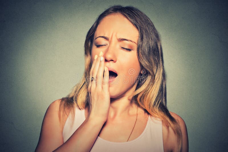 It is too early for meeting. Closeup portrait sleepy young woman with wide open mouth yawning eyes closed looking bored on gray wall background. Face expression emotion body language