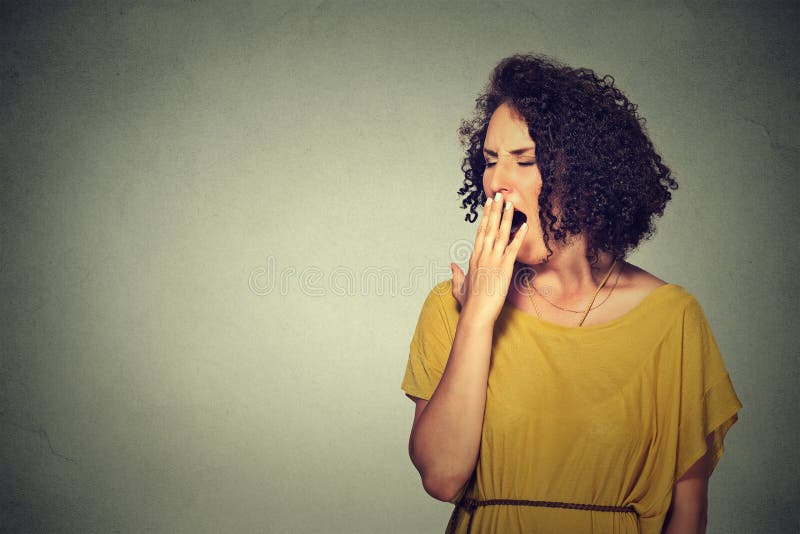 It is too early for meeting. Closeup portrait sleepy young woman with wide open mouth yawning eyes closed looking bored isolated grey wall background. Face expression emotion body language