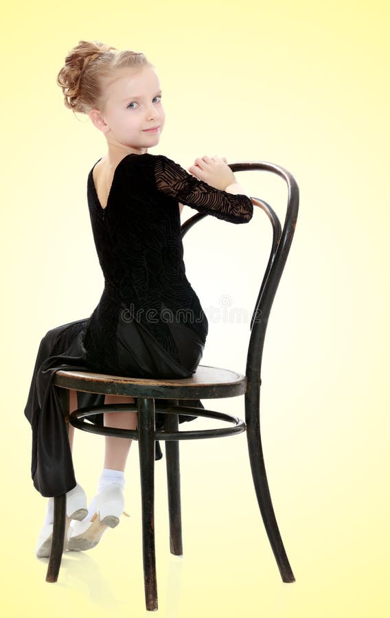 Slender little dancer posing near the old Vienna chair.