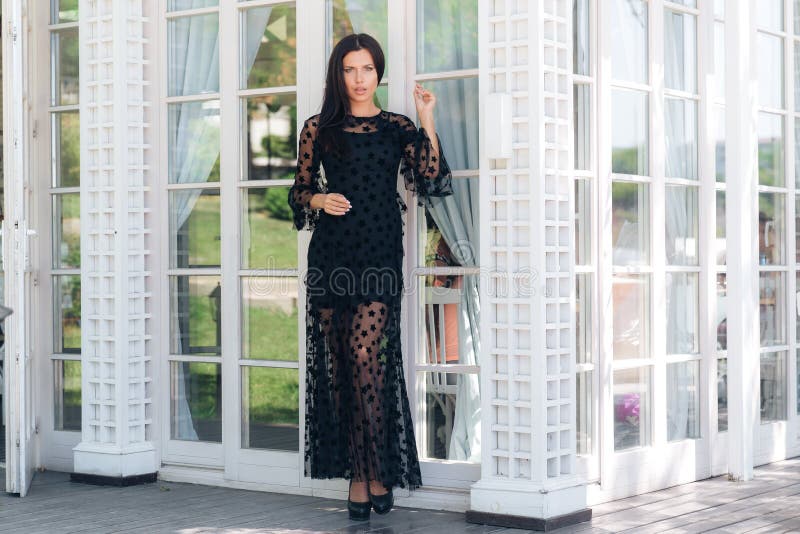Slender high European girl in an expensive tight black dress leaves the restaurant on the street. Corrects dark royalty free stock photography Slender high European girl in an expensive tight black dress leaves the restaurant on the street. Corrects dark royalty free stock photography