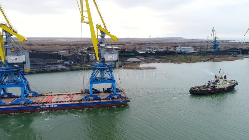Slepende kranen voor containers Groot die containerschip door sleepboten wordt getrokken Top down luchtmening De vracht van de co royalty-vrije stock afbeelding Slepende kranen voor containers Groot die containerschip door sleepboten wordt getrokken Top down luchtmening De vracht van de co royalty-vrije stock afbeelding