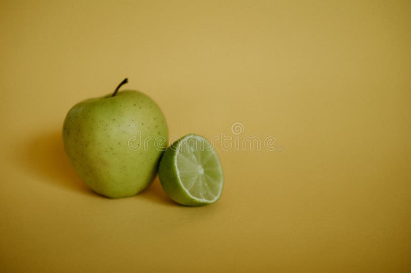 Slice Apple και Lime σε κίτρινο φόντο στοκ εικόνες με δικαίωμα ελεύθερης χρήσης