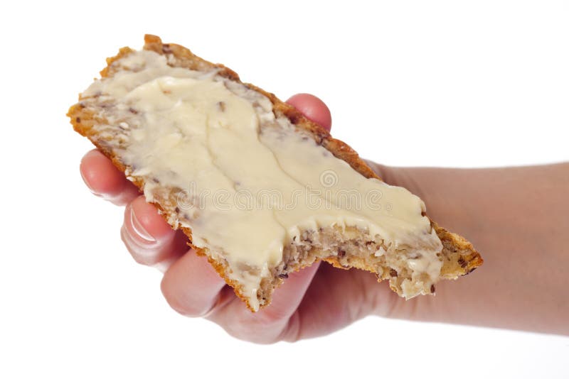 Slice of bread in hand holds a peanut butter