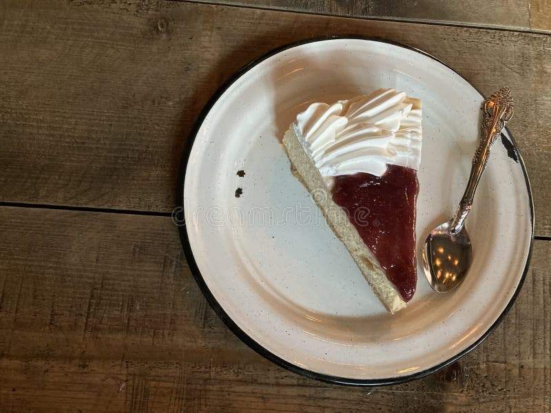 Slice Cheesecake with strawberry jelly, in a pewter plate ready for desser. Slice Cheesecake with strawberry jelly, in a pewter plate ready for desser