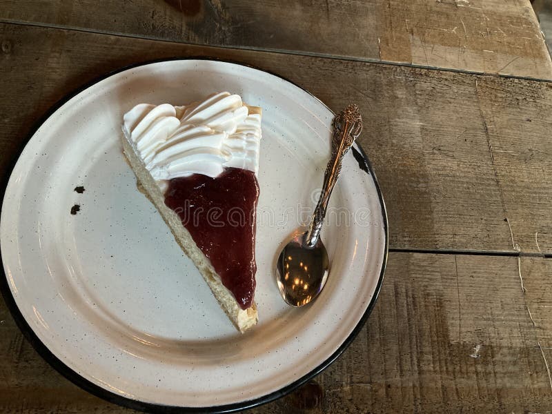 Slice Cheesecake with strawberry jelly, in a pewter plate ready for desser. Slice Cheesecake with strawberry jelly, in a pewter plate ready for desser