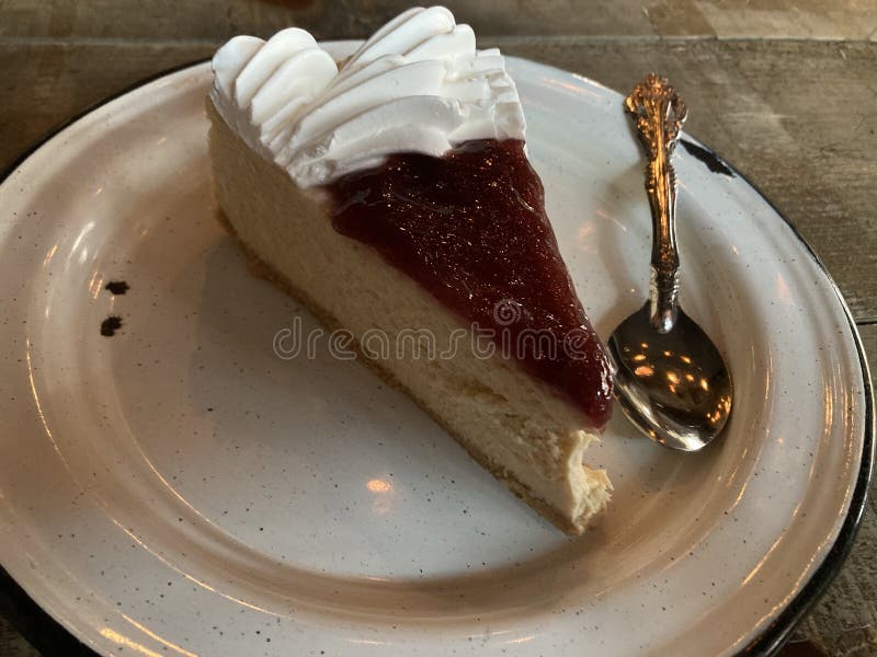 Slice Cheesecake with strawberry jelly, in a pewter plate ready for desser. Slice Cheesecake with strawberry jelly, in a pewter plate ready for desser