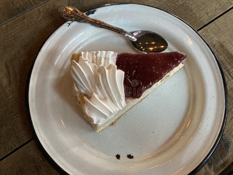 Slice Cheesecake with strawberry jelly, in a pewter plate ready for desser. Slice Cheesecake with strawberry jelly, in a pewter plate ready for desser