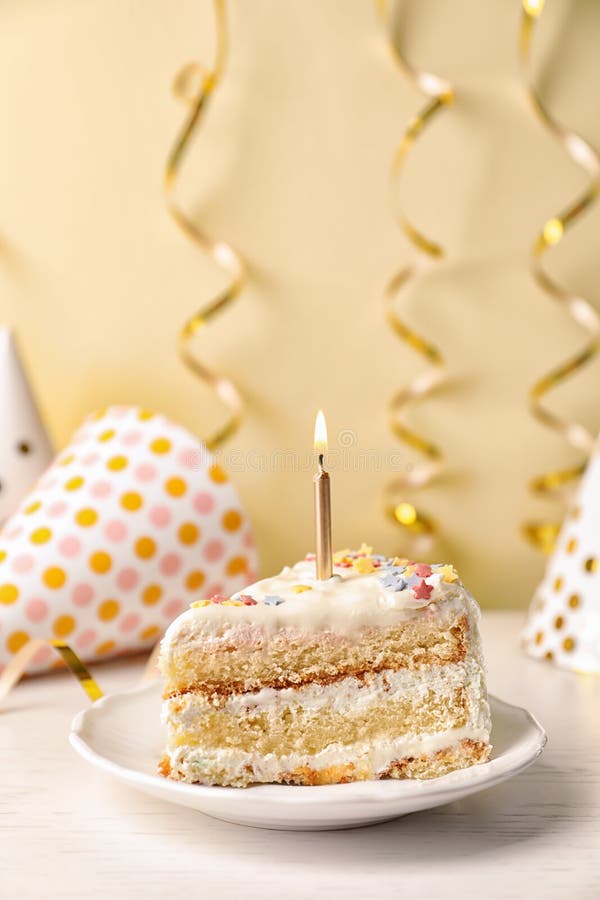 Slice of Delicious Birthday Cake with Candle on Table Stock Photo